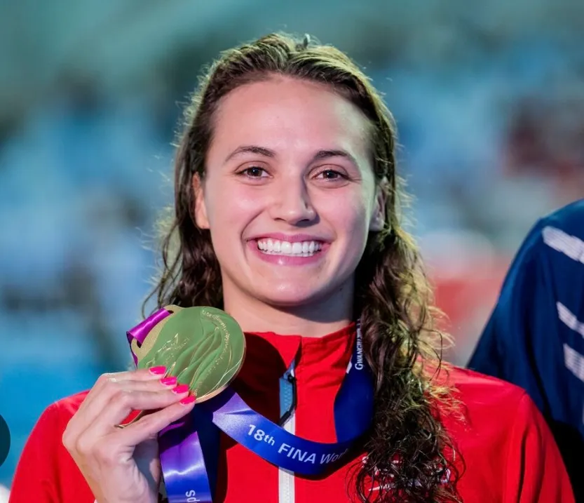 Competitive swimmer diving into pool at start of race, demonstrating elite swimming technique